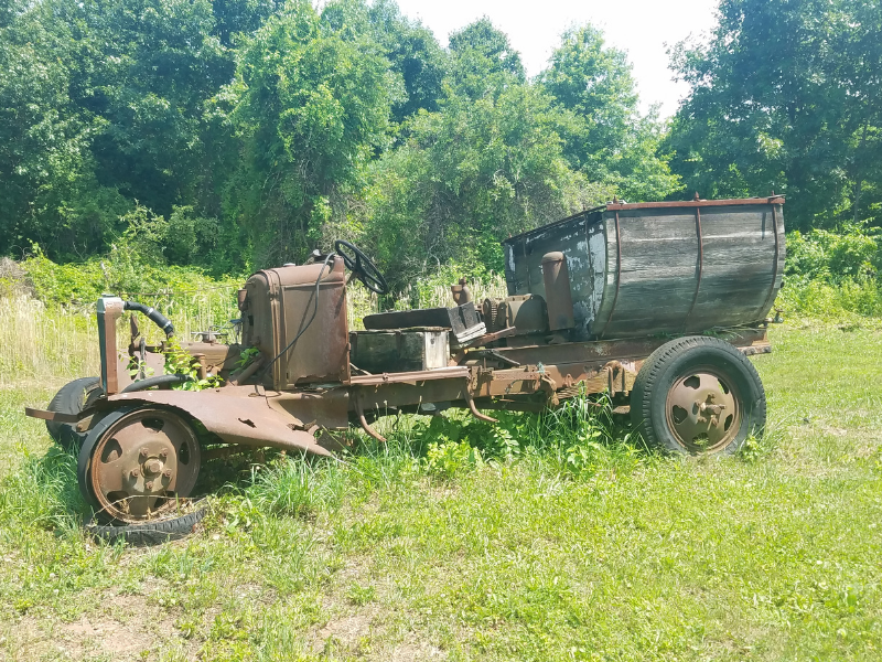 old and abandoned spray applicator truck in orchard field