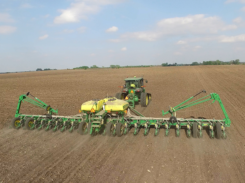 Large tractor and soybean planter in field. Photo taken with drone.