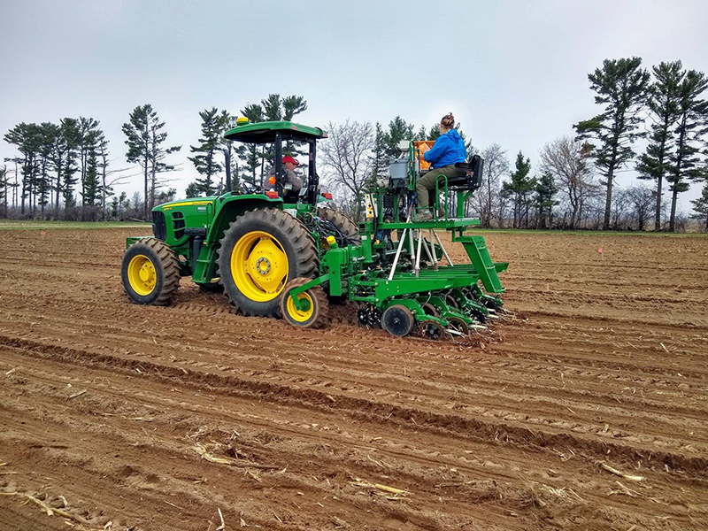 Tractor and soybean planter seeding research plot.