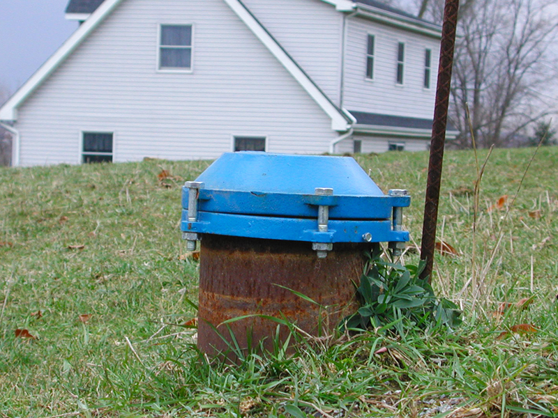 Well water cap in residential yard.