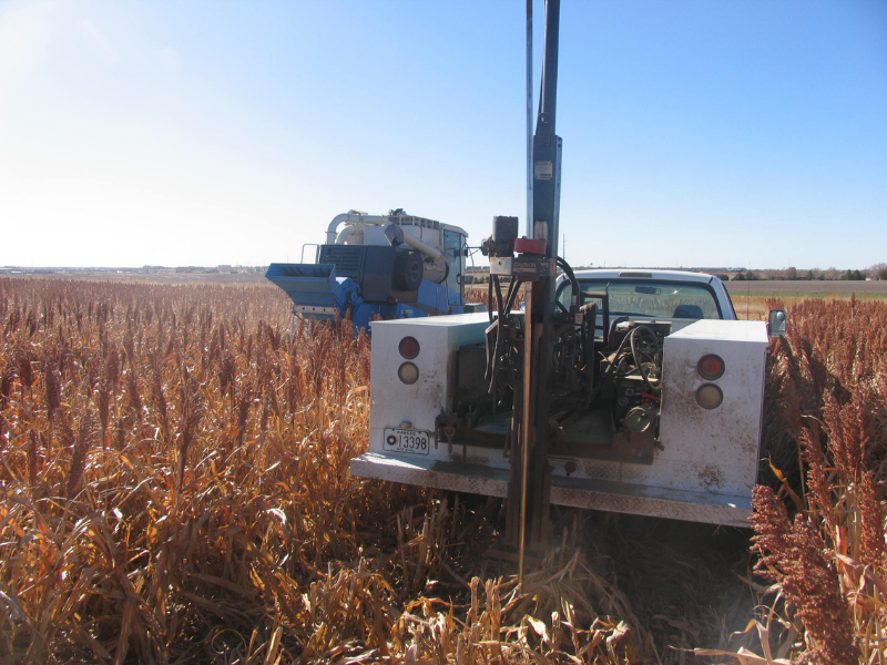 truck, tractor and equipment harvesting and collecting soil samples in sorghum field