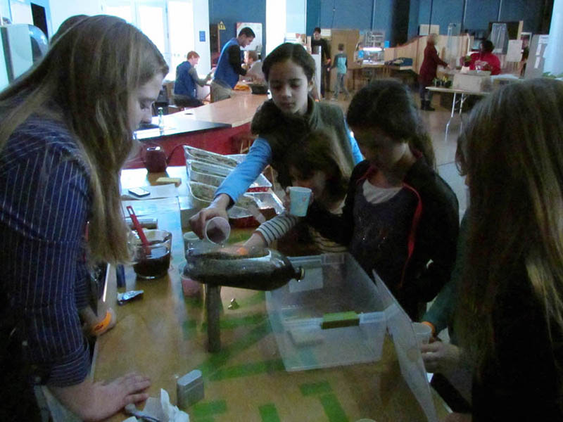 Adult and children doing a soils activity