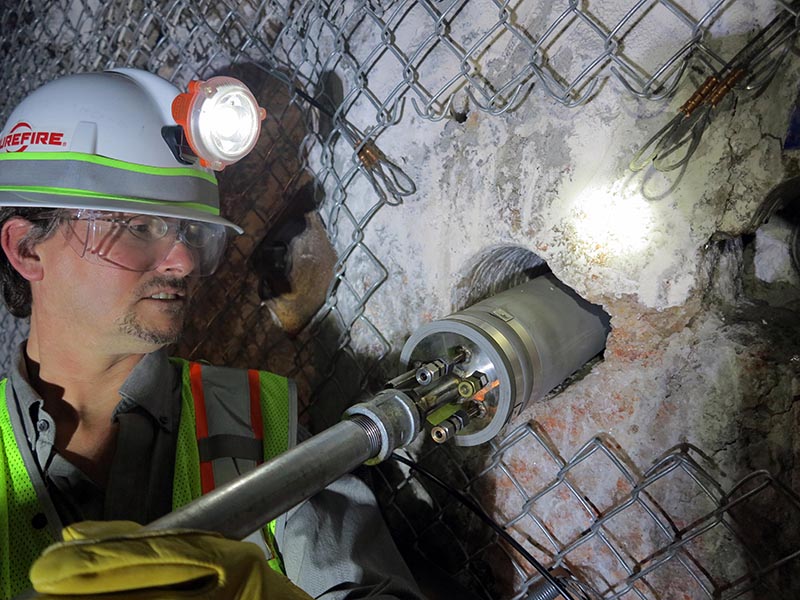 Scientist testing equipment fit into bored hole