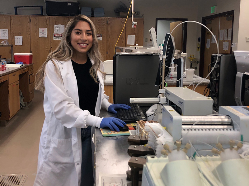 researcher posing by equipment