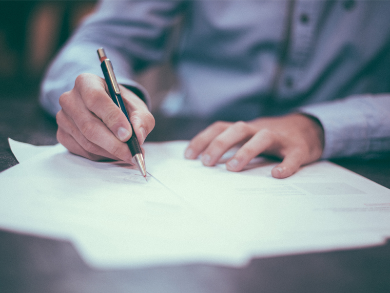 hands writing a letter