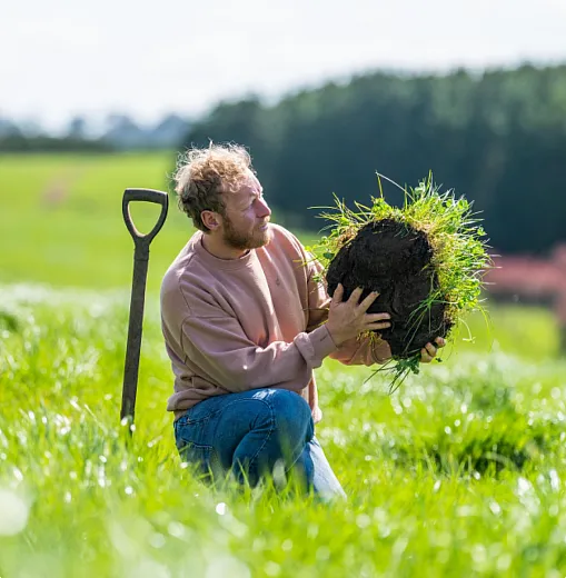 Man holding up a bundle of soil